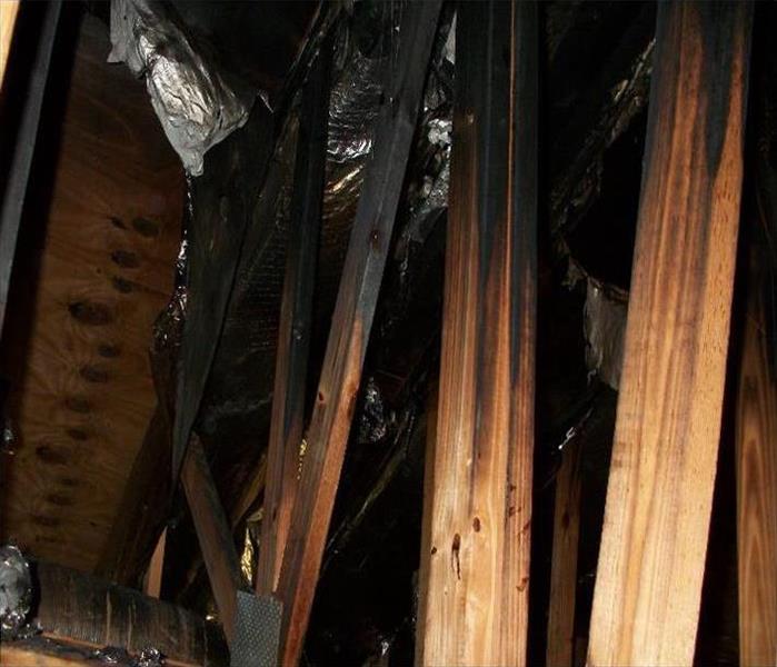 exposed rafters, burnt black in areas